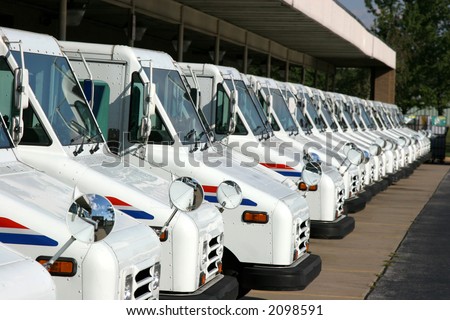 Some postal delivery trucks in line