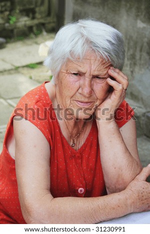 Sad senior woman holding her hand over head