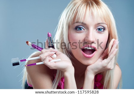 Surprised girl with makeup in the hands of