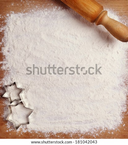 Rolling pin, flour and forms for cookies on the boards