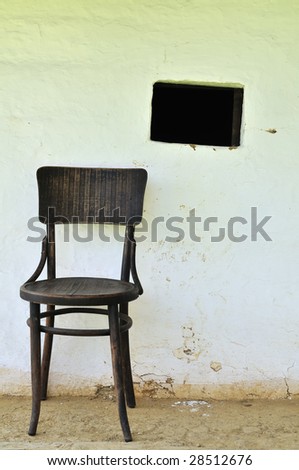 Very old chair with window at outdoor museum in Pityerszer, Hungary. (detail of oldest type of the houses in the region)