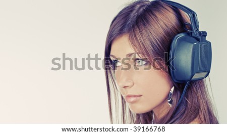 Beautiful young woman listening music and looking afar