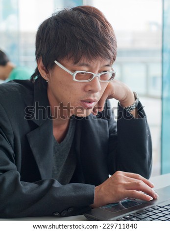 businessman working in office, sitting at desk, looking at laptop computer screen
