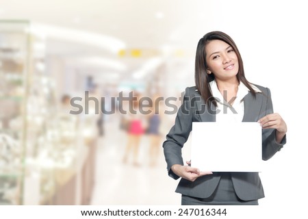 Portrait of young asia business woman 20 -30 year hold banner has pace for the words or letters.old in her office.Mixed Asian / Caucasian businesswoman.Positive emotion