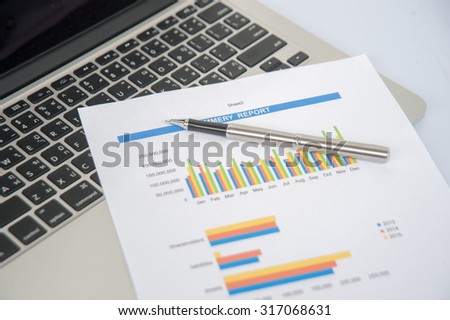 Report and pen on Notebook ,business finance, tax, accounting, statistics and analytic research concept