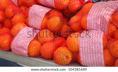 At a Farmers\' Market: Organically grown oranges are on display and bagged for sale