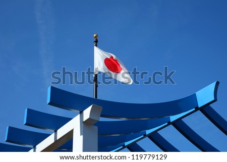 The Japanese flag is glimpsed through a structure with an Asian theme