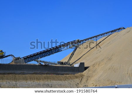 BAKERSFIELD, CA-MAY 7, 2014: As work nears 30% completion on the project to widen State Route 178 excavated material is crushed, then conveyed to a gigantic mound of road base.