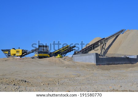 BAKERSFIELD, CA-MAY 7, 2014: As work nears 30% completion on the project to widen State Route 178 excavated material is crushed, then conveyed to a gigantic mound of road base.