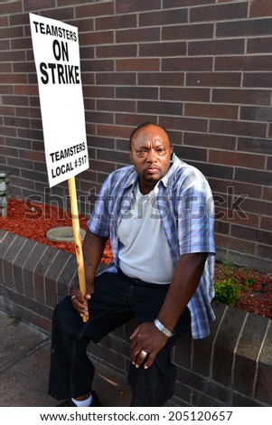 BAKERSFIELD, CA-JULY 15, 2014: After six months failed negotiations the teamsters union strikes the Golden Empire Transit District. An unidentified union member takes a break from the extreme heat.
