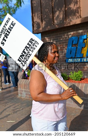 BAKERSFIELD, CA-JULY 15, 2014: After six months failed negotiations the teamsters union strikes the Golden Empire Transit District. An unidentified woman walks the line in extreme heat.