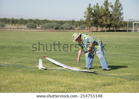 BAKERSFIELD, CA-AUGUST 24, 2014: George Gillburg retrieves his craft after a long thermal flight in the monthly contest hosted by the Southern San Joaquin Soaring Society.