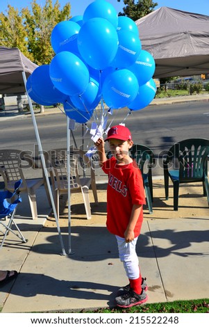 WASCO, CA - SEPTEMBER 6, 2014: Hayden Garrison\'s mission is to give away all his blue balloons before the start of the  parade at the city\'s Festival of Roses.