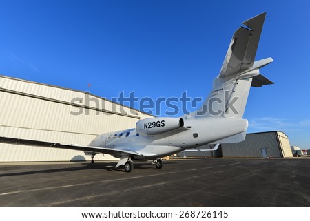SHAFTER, CA - APR 11, 2015: This corporate jet, an Embraer Phenom 300, is parked on the ramp, ready for the hangar doors to open and routine maintenance to begin.