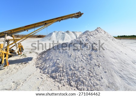 Materials handling equipment and conveyor belts work amid piles of borax near an agricultural chemical plant.