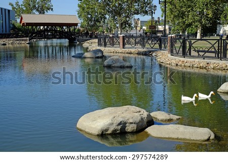 BAKERSFIELD, CA - JULY 17, 2015: An irrigation canal is also used as part of an urban renewal project. Despite the current severe drought, cooling water still flows under the Mill Creek Park bridge.