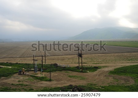 A newly planted California farm field with electric substation for local power