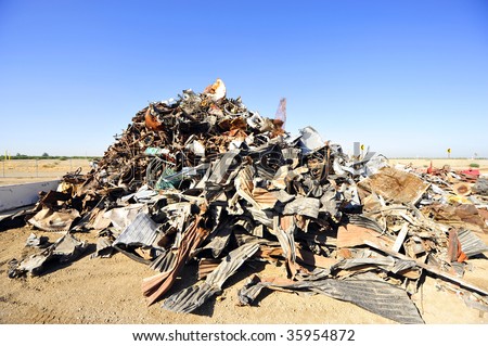 A very large trash pile at a salvage yard illustrates the throw away society