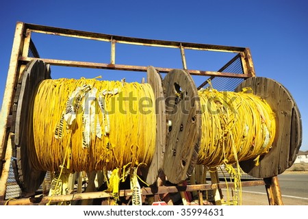 Yellow polypropylene rope with caution banners attached is used for event crowd control and stored on reels