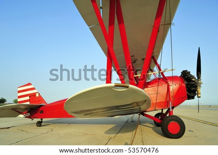 This antique red biplane is similar to those of the barnstorming era