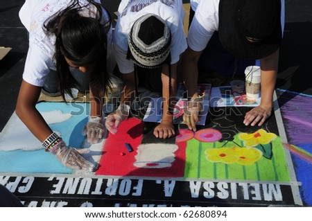 BAKERSFIELD, CA - OCT 9: Local students and artists apply chalk to asphalt for the Via Arte Italian Street Painting Festival on October 9, 2010 in Bakersfield, California