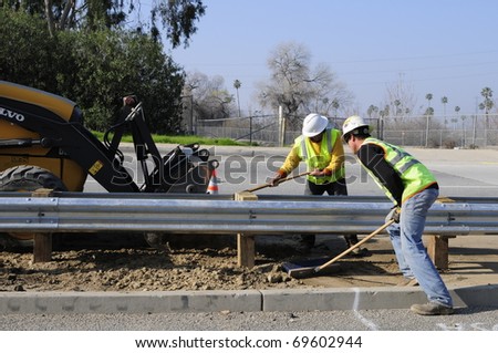 BAKERSFIELD, CA - JAN 22: Construction for the Manor Street on ramp is completed on January 22, 2011, at Bakersfield, California. Workmen clean area under new guard rails.
