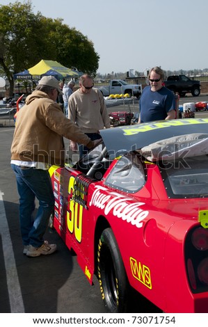 BAKERSFIELD, CA - MAR 12: NASCAR sponsor holds public auction for all their cars and parts on March 12, 2011 in Bakersfield, California. Buyers inspect racing cars prior to bid.
