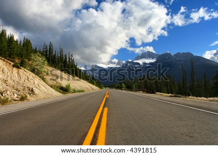 Nicely paved road into the mountains.  Conceptual idea for taking the high road or taking the road to the top.