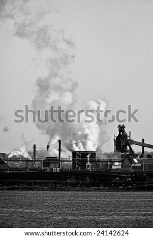 Smoke and steam polluting the environment at a manufacturing plant.