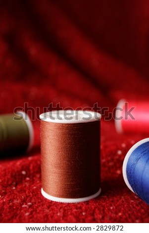 Spools of thread on a fabric background.