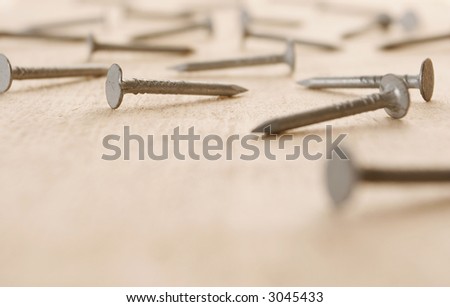 Nails lying on a wooden board - room for text.