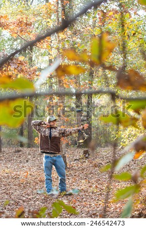 southern american teen boy out in the woods bow hunting for deer