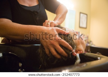 mature woman getting her hair cut at a home salon