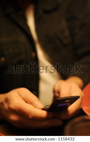 Older man\'s hands texting someone with his cell phone.