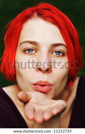 Young woman blowing a kiss, or some fairy dust.