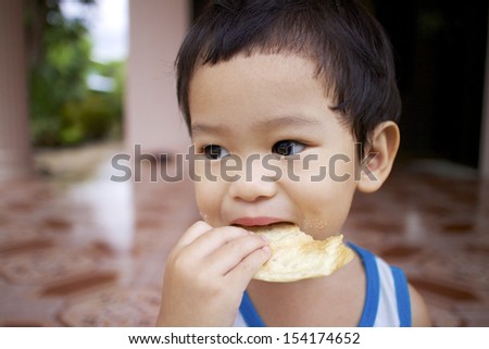 Asian boy eating candy