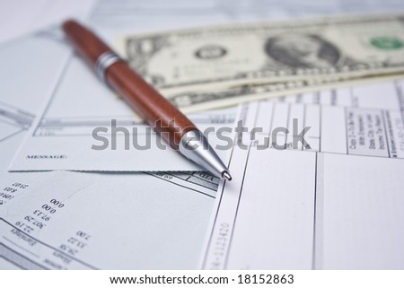 pay checks, pen and US dollars