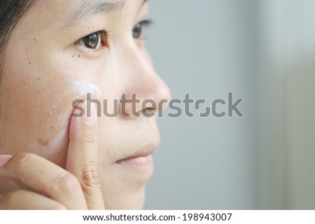 woman applying make up by cream foundation