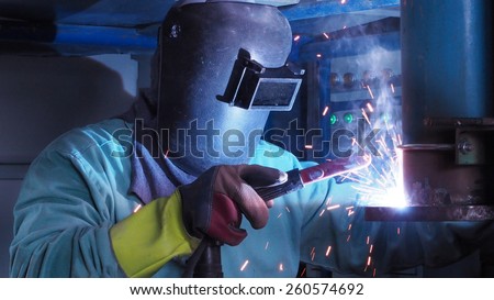 Industrial worker welding steel pipe flange,a spark welding.