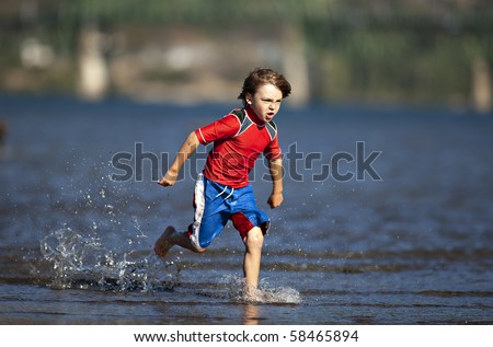 A boy runs and plays in the water