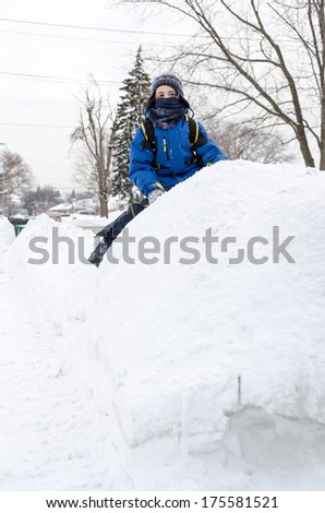In the way to school, a boy has fun with the huge piles of snow accumulated on the side walk