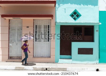 SANTA CLARA, CUBA-JUNE 28, 2014: The scorching heat in the island has forced many to use umbrellas to protect the skin against the ultraviolet rays and avoid skin cancer.