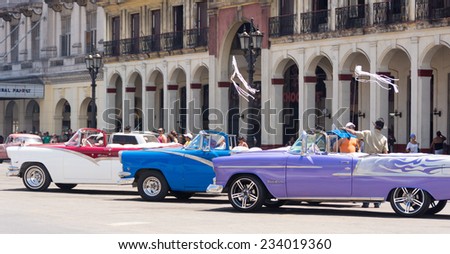 HAVANA,CUBA-JULY 3,2014: Old American cars running and making income for owners. The car supply limitations has made Cubans innovate to keep cars from the 50\'s running and make income with them.