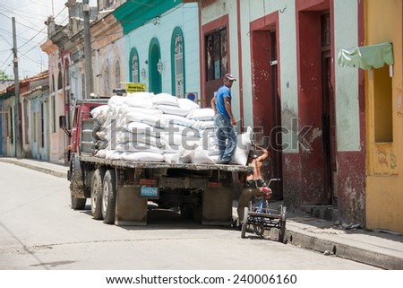 SANTA CLARA,CUBA-JULY 4,2014: Unloading a truck of flour in a Cuban dining room for people in need or social cases. One of the major achievements of the Cuban Revolution is serve those in need.