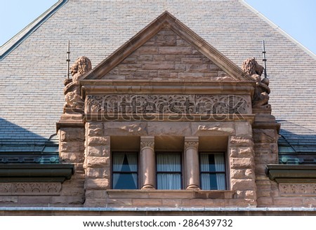 Ricardsonian Romanesque revival architecture : Queen\'s Park building beautiful window with lions under the roof of the Ontario Legislative Building.