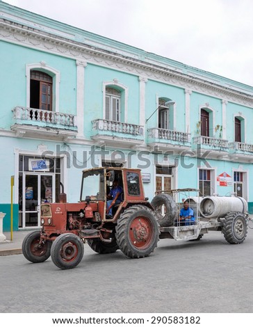 SANTA CLARA,CUBA-JULY 14,2014: Cuban images: Old soviet tractor pulling a trailer on the street Cuban city. Changes in the economic model are happening by the day.