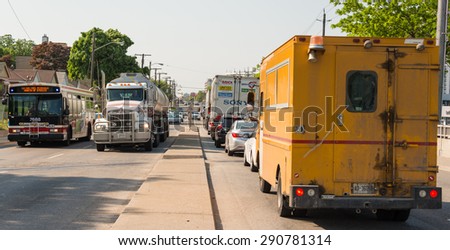 TORONTO,CANADA-JUNE 12,2015: Daily traffic jams in Toronto: Commercial semi-trucks and food truck traveling on crowded four lane road.