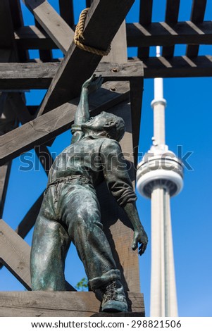 TORONTO,CANADA-JUNE 15,2015: The Chinese Railway Workers Memorial with the CN Tower in the background. the landmark is dedicated to the Chinese railroad workers