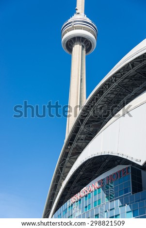 TORONTO,CANADA-JUNE 15,2015: The roof of Rogers Centre stadium and exterior of the Renaissance Hotel with the CN Tower in the background. Rogers Centre is a multi-purpose stadium in downtown Toronto