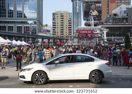 TORONTO,CANADA-JULY 1,2015:People crowd in Dundas Square the streets during Canada Day. Canada Day is celebrated annually and is a national holiday.